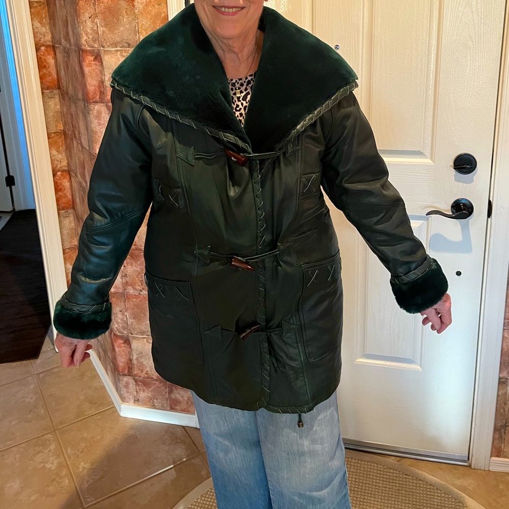 Leather coat with fur-lined cuffs and hood. Size S with a generous fit.
